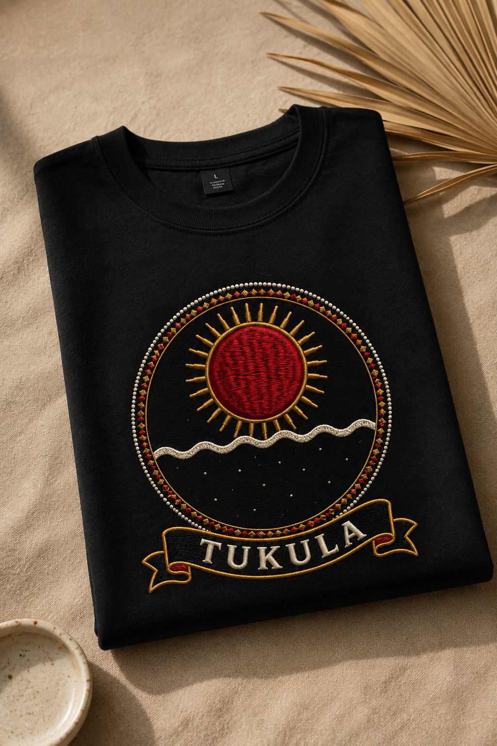Tukula black tee flat-lay on linen, Dikenga Collection by Bana Bilaka