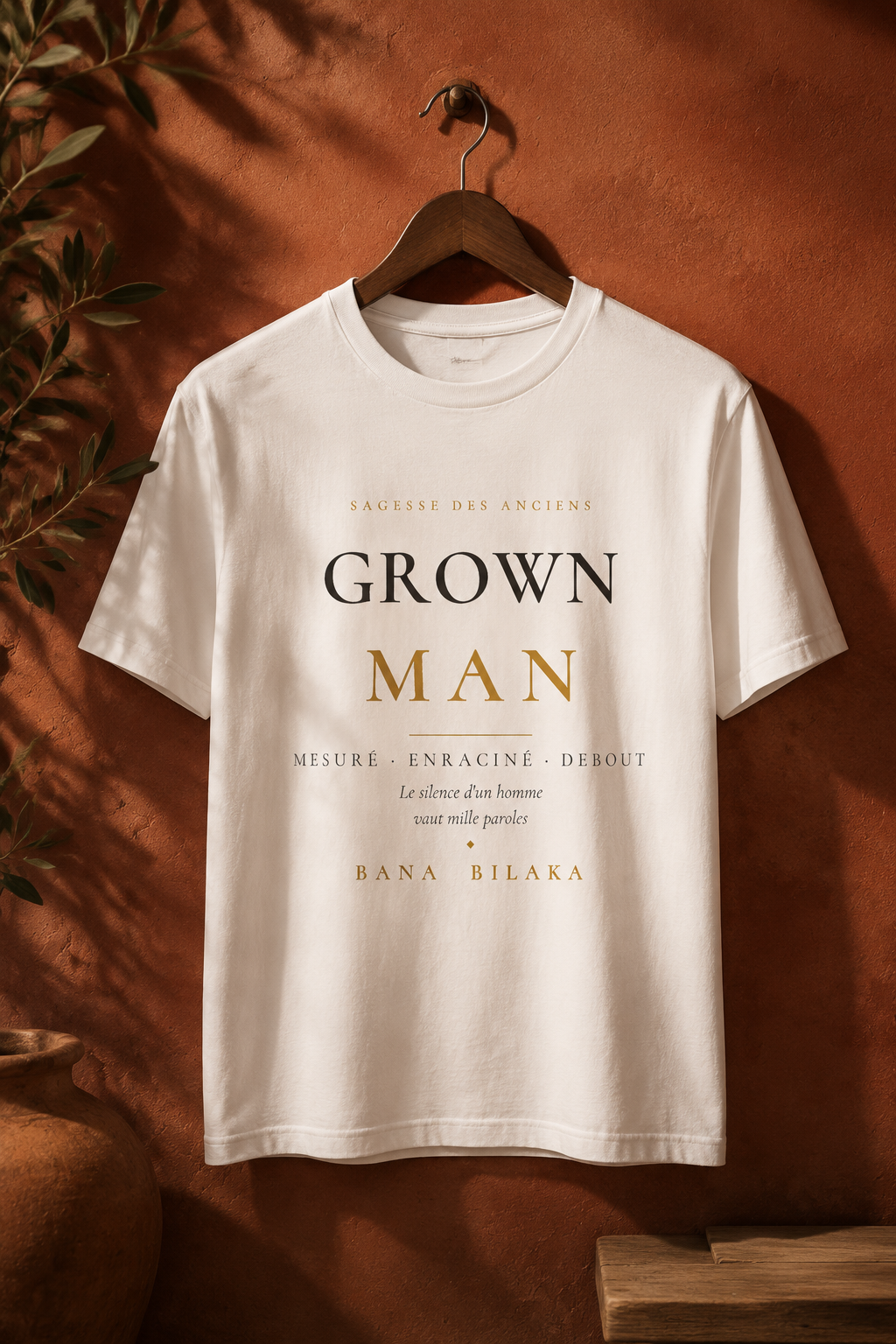 Bana Bilaka Grown Man — t-shirt blanc sur cintre, ambiance boutique terracotta