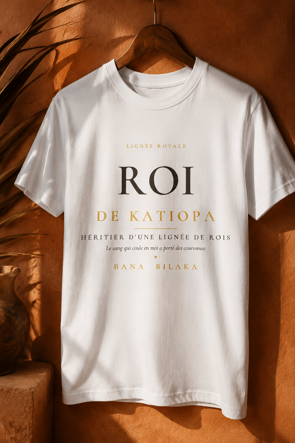 Bana Bilaka Roi de Katiopa — t-shirt blanc sur cintre, ambiance boutique terracotta