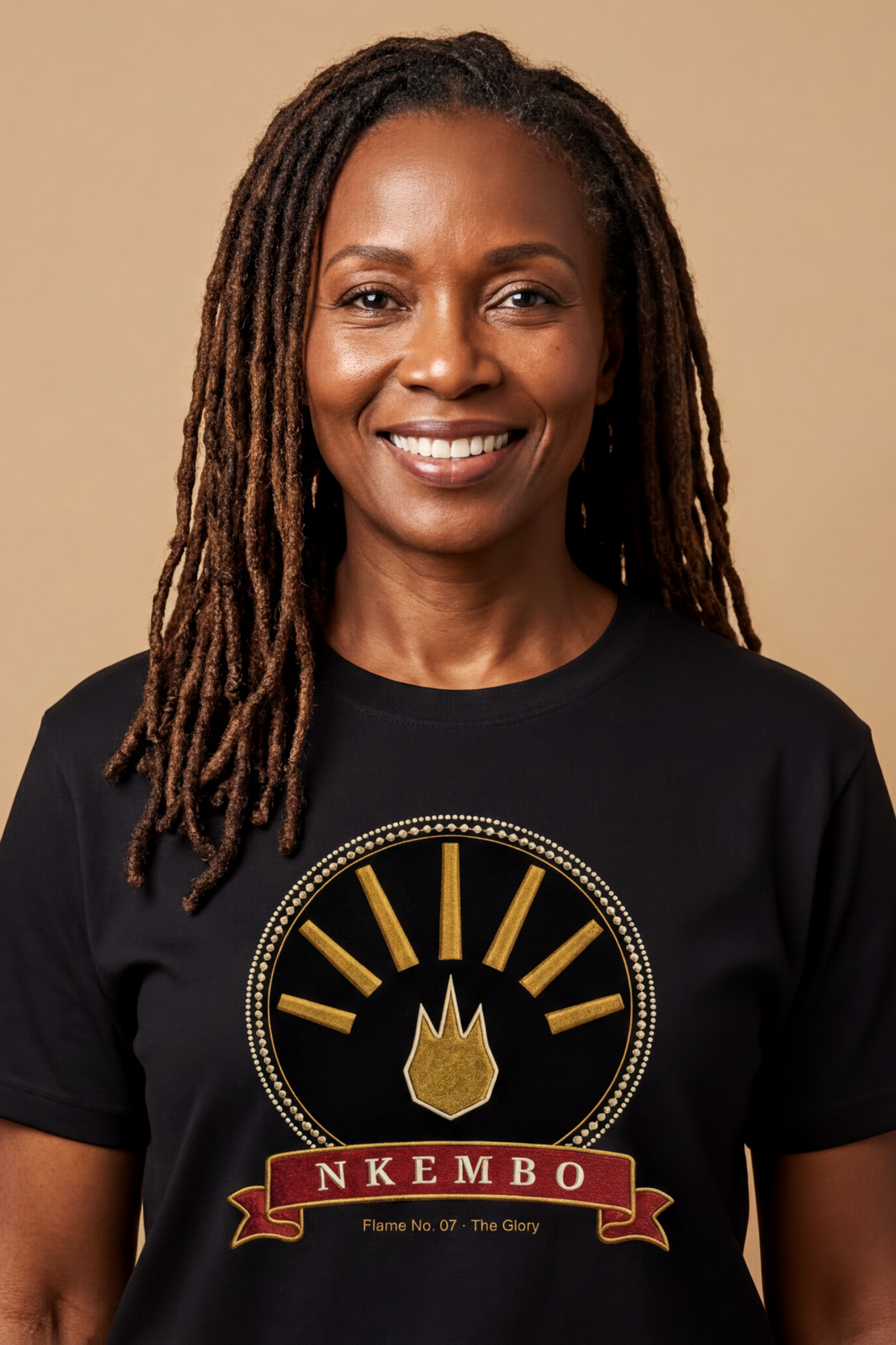 Woman with locs wearing the black Nkembo tee, deep gold flame with seven rays, The Twelve Flames collection by Bana Bilaka