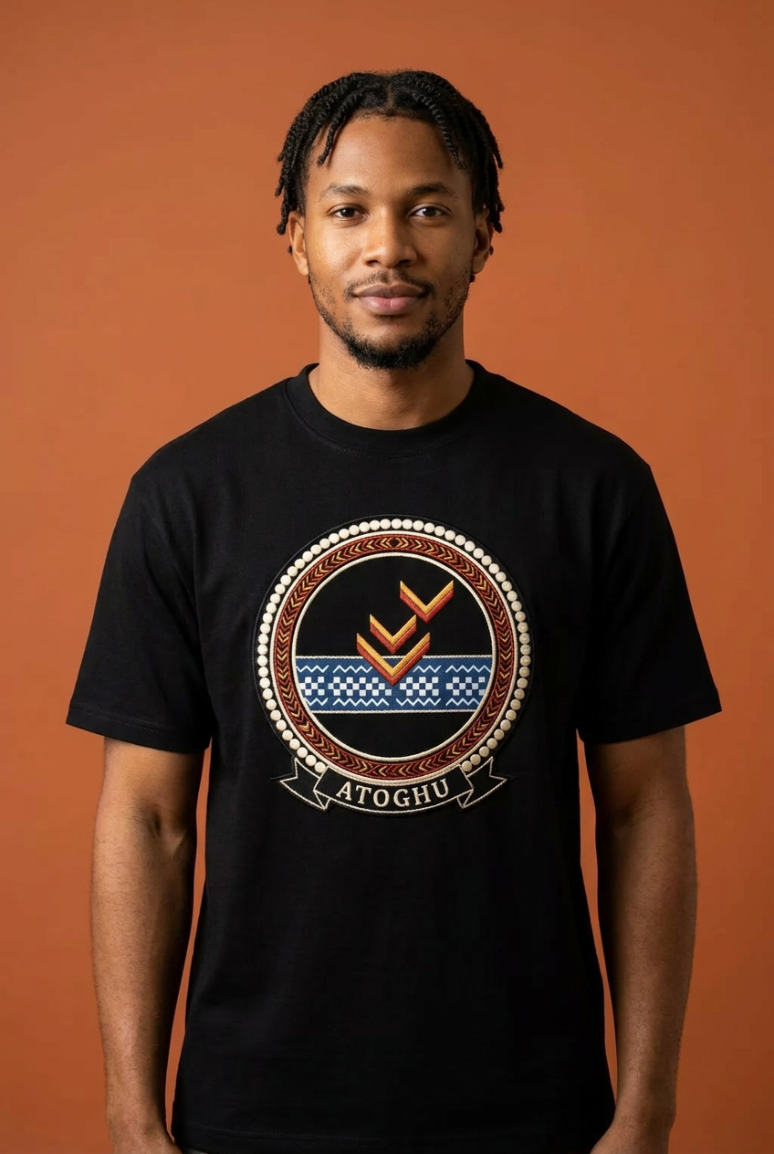 Modèle portant le tee noir Atoghu, médaillon imprimé effet broderie où le chevron toghu rencontre la bande indigo ndop, Cameroon Grassfields collection par Bana Bilaka