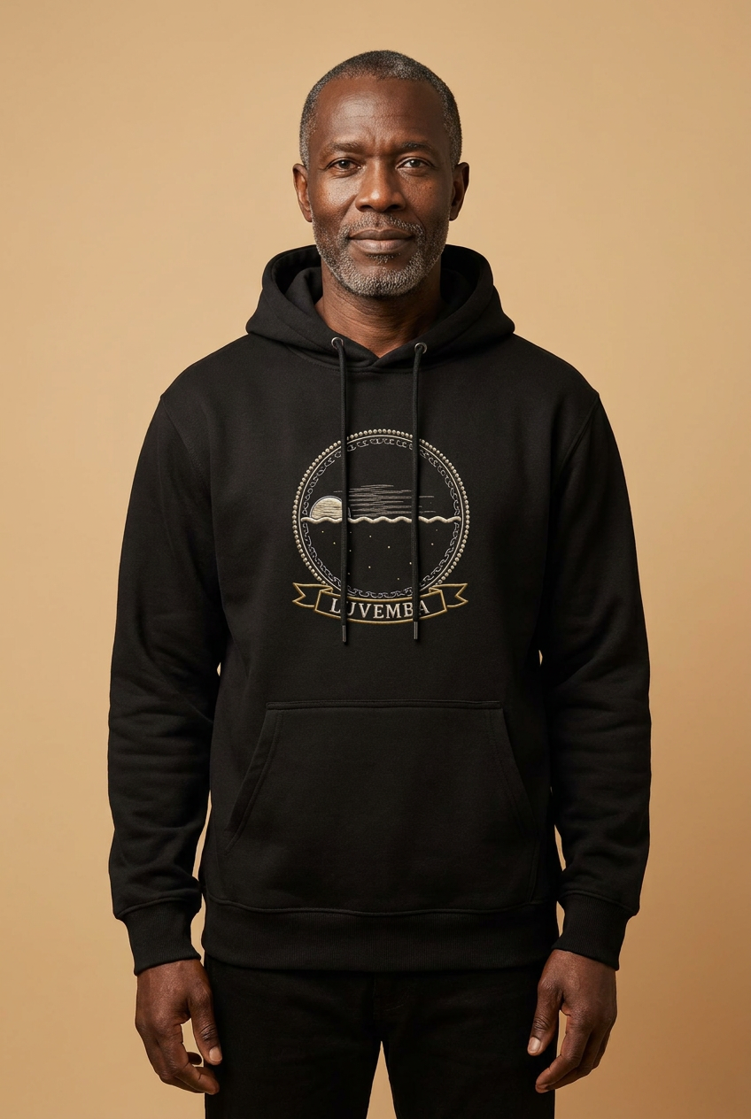 Luvemba jet black hoodie worn by a model, embroidery-style Kongo emblem printed as a chest crest, Dikenga Collection by Bana Bilaka