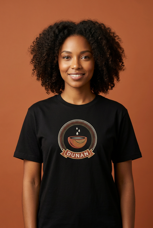 Modèle portant le tee noir Dunan, médaillon imprimé effet broderie à la calebasse d'eau, Collection Le Serment du Manden par Bana Bilaka