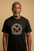 Modèle portant le tee noir Kalikan, médaillon imprimé effet broderie au sautoir lance et louche-calebasse, Collection Le Serment du Manden par Bana Bilaka