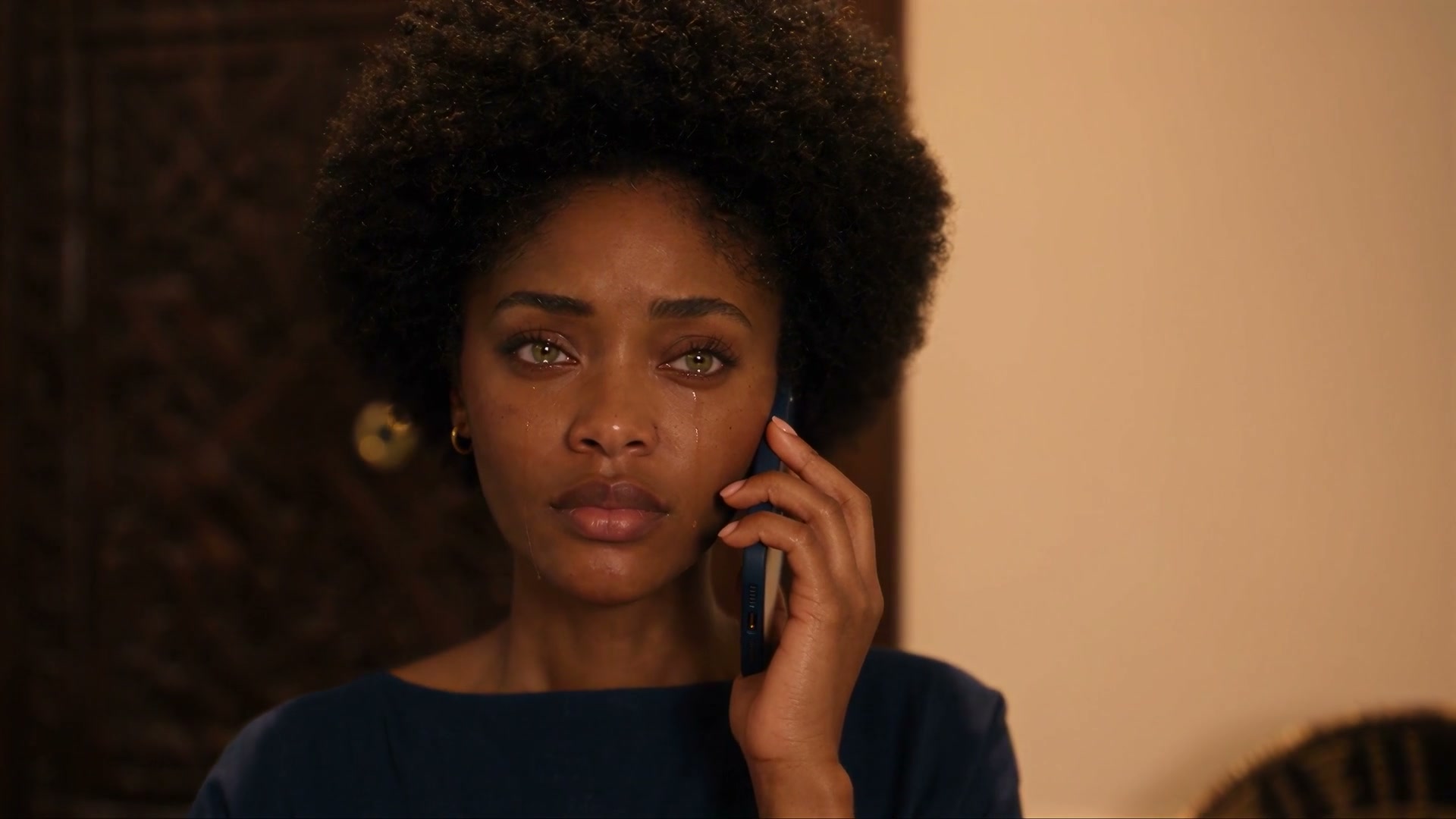 Aya au téléphone, une larme sur la joue, Koffi, les chaînes invisibles