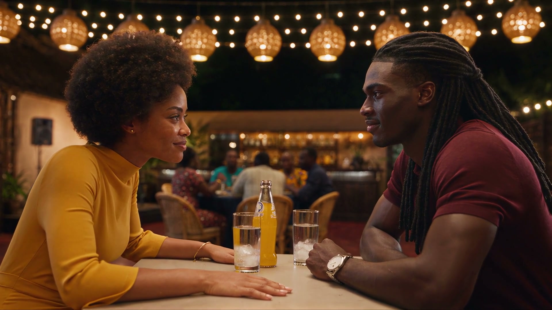 Aya et Koffi se regardent à la table d'un maquis le soir, guirlandes de lampions au-dessus d'eux, Koffi, les chaînes invisibles
